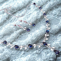 Jewelry set with necklace and earrings on a textured gray background
