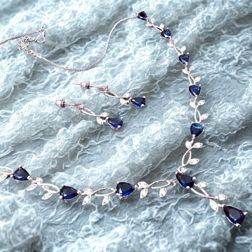Jewelry set with necklace and earrings on a textured gray background
