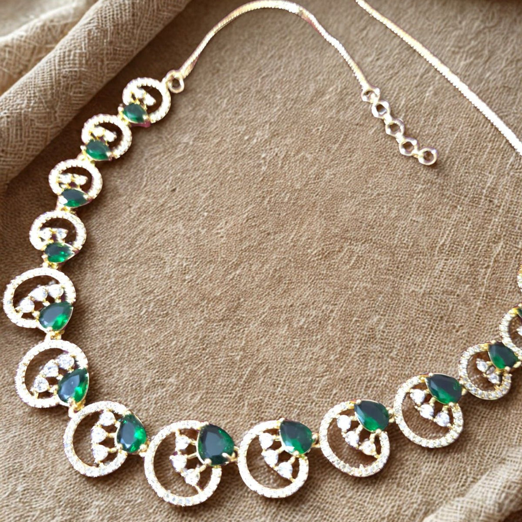Necklace with green gemstones on a beige fabric background