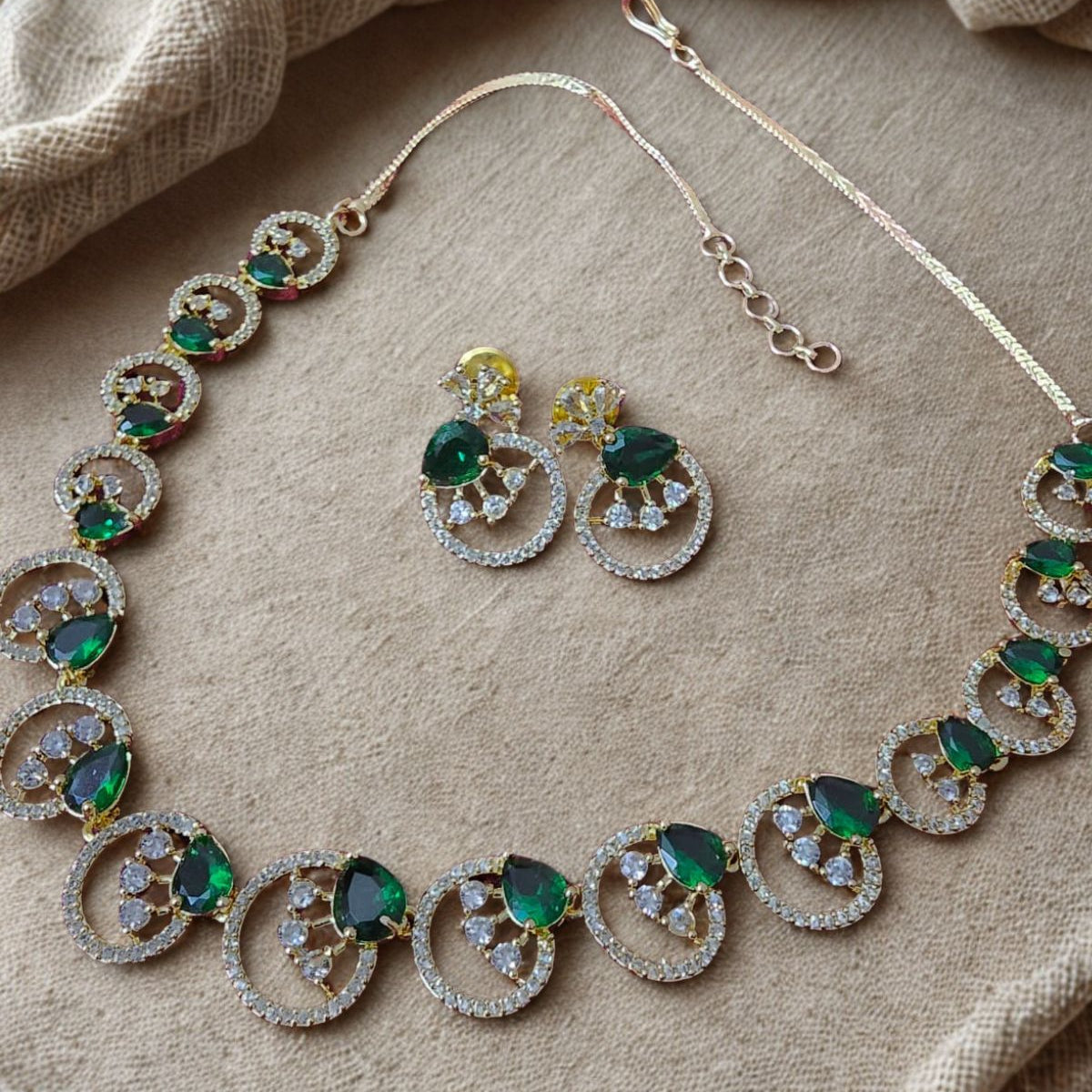 Jewelry set with necklace and earrings on a beige fabric background
